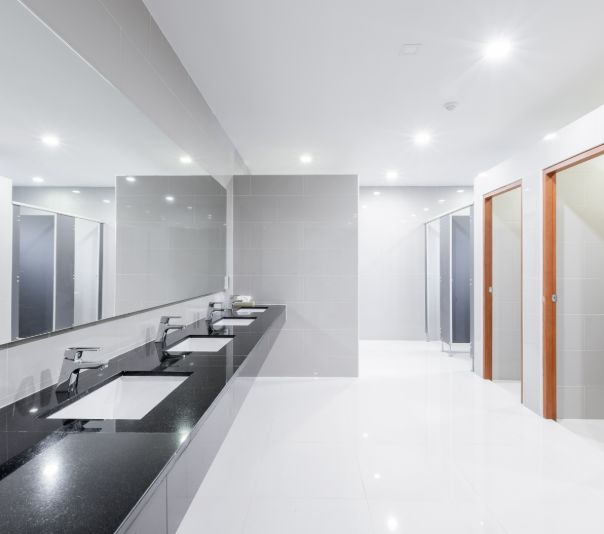Modern, clean public restroom with sinks and stalls.